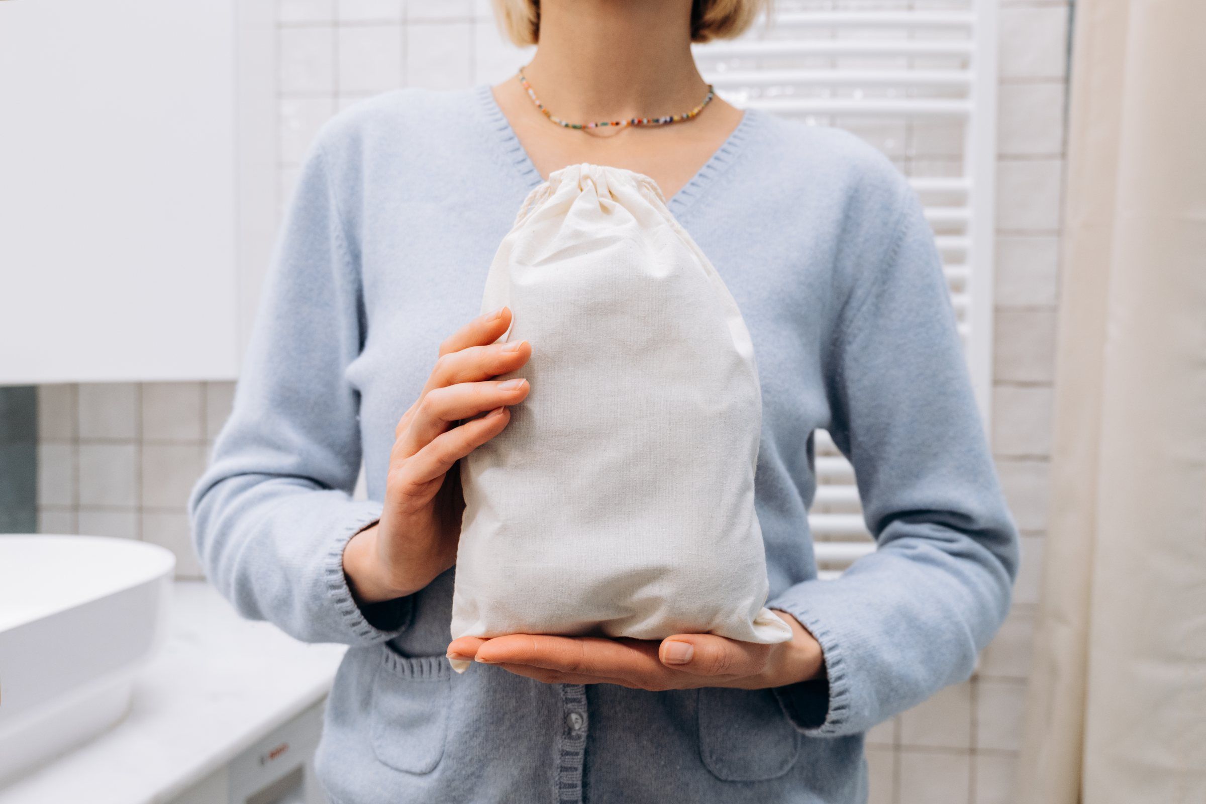 A woman holding a Wooly Heroes drawstring bag